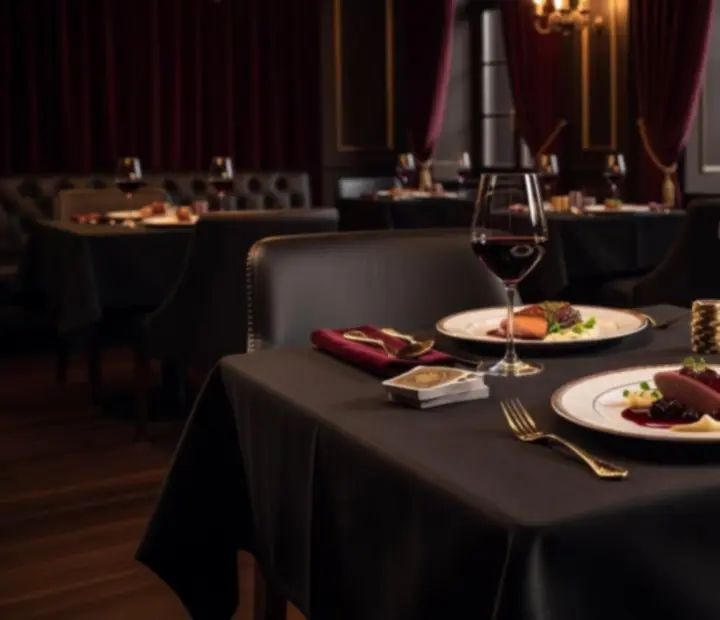 Elegánsan megterített asztal gourmet fogásokkal és hangulatos fényekkel